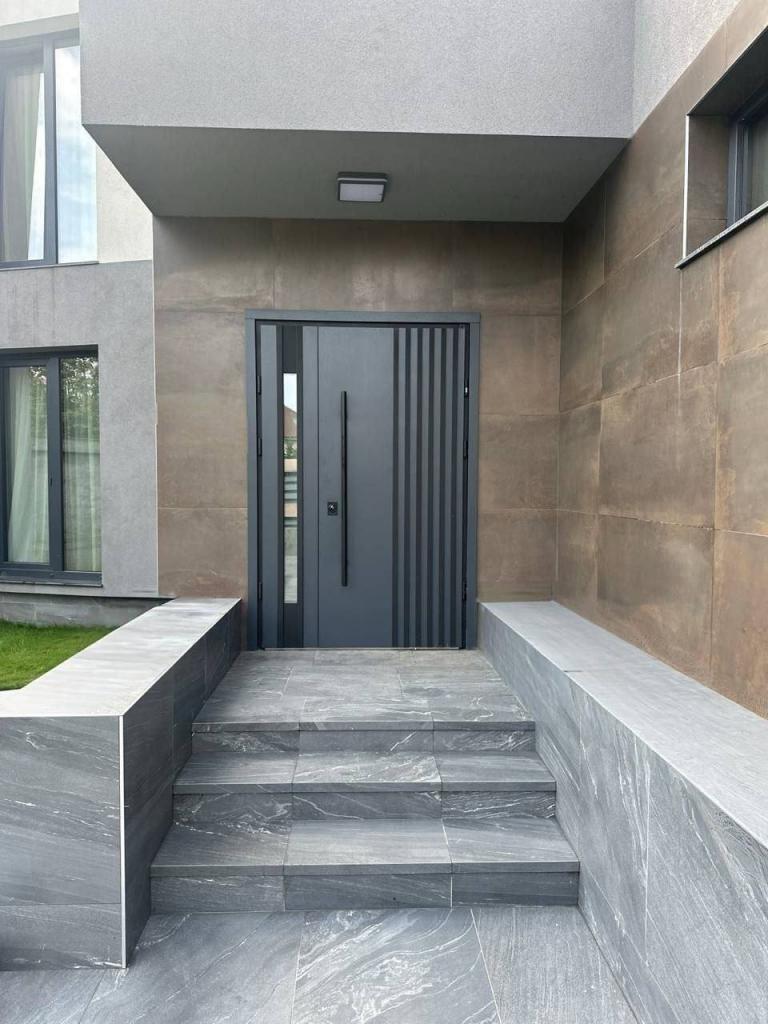 Puerta acorazada de entrada elegante de Puertas Guardamar en negro y gris acero
